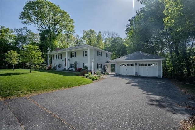 137 Naugler Ave, Marlborough, MA 01752 - bi-level home with a detached garage, an outbuilding, a front lawn, and view of wooded area