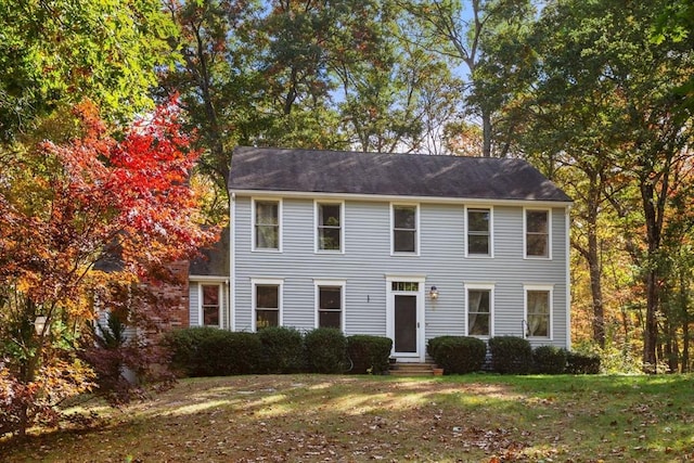 colonial inspired home with a front yard and entry steps