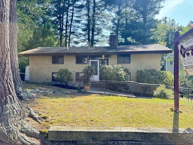 11 Hutchins Cir, Lynnfield, MA 01940 - view of front of property with stucco siding, a chimney, and a front yard