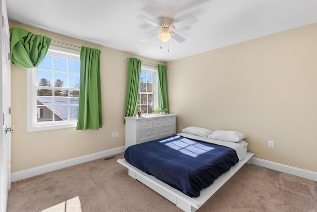 bedroom featuring baseboards, ceiling fan, visible vents, and light colored carpet