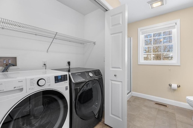 clothes washing area featuring laundry area, visible vents, baseboards, and independent washer and dryer