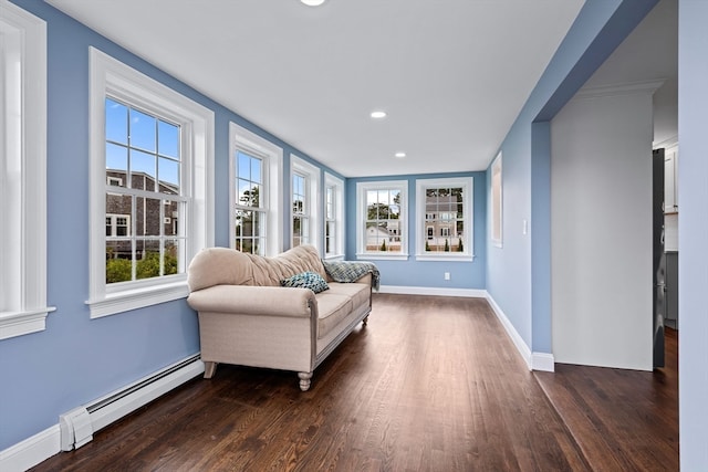 living area featuring dark wood-type flooring and a baseboard heating unit