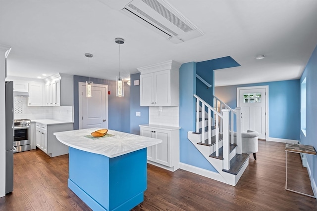 kitchen featuring stainless steel range oven, dark wood-type flooring, white cabinets, a kitchen island, and backsplash