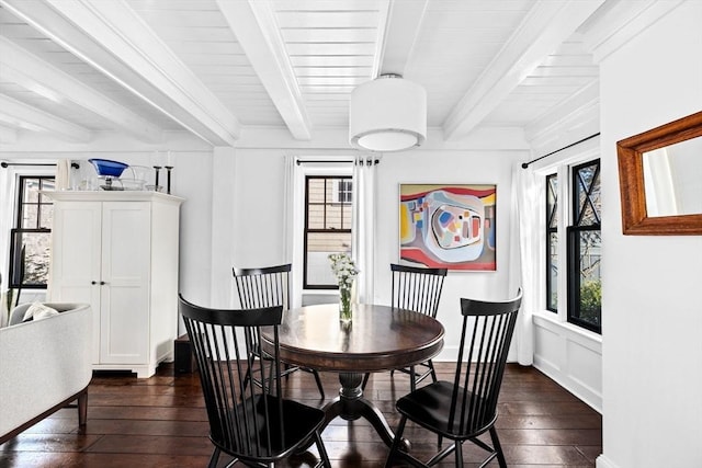 dining space with dark hardwood / wood-style floors and beam ceiling