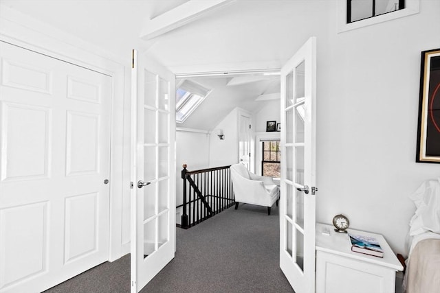 hallway with dark carpet, lofted ceiling with beams, and french doors