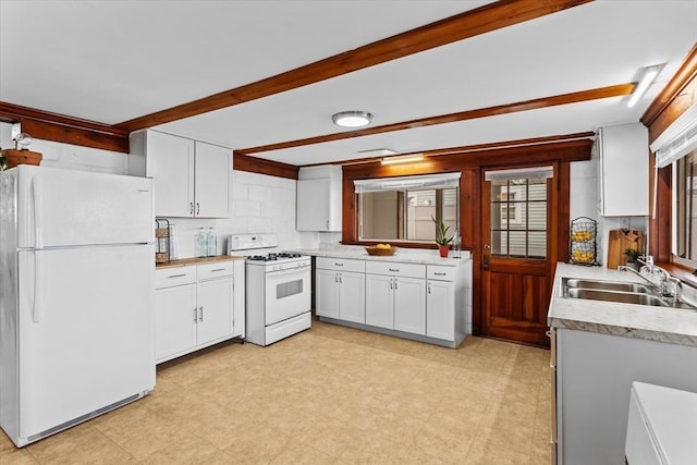 kitchen with white appliances, white cabinetry, a sink, and light countertops