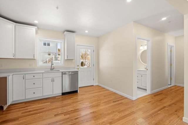 kitchen with dishwasher, a sink, light wood-style floors, white cabinets, and recessed lighting