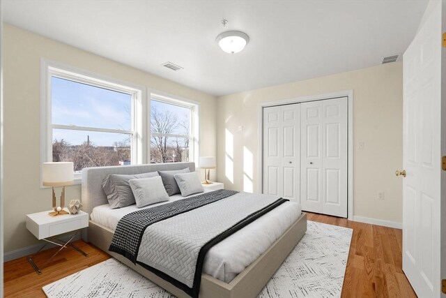 bedroom with a closet, baseboards, and light wood-style flooring