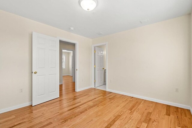 unfurnished bedroom with light wood-type flooring and baseboards