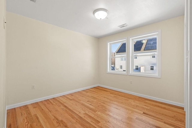 empty room featuring baseboards and light wood finished floors