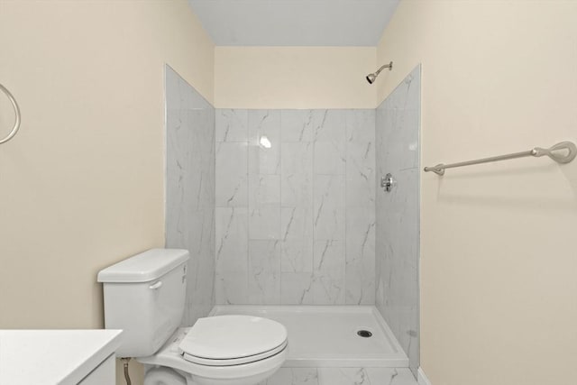 bathroom featuring marble finish floors, toilet, a shower stall, and vanity