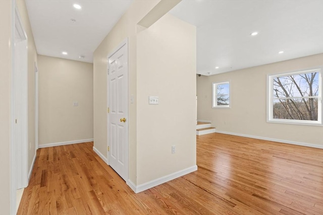 hallway with light wood-type flooring, recessed lighting, and baseboards