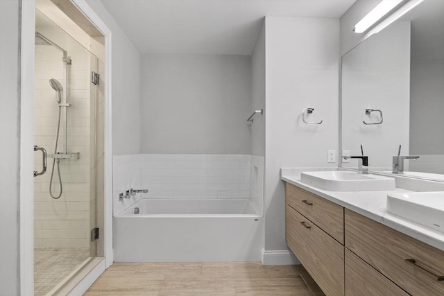 bathroom featuring vanity and independent shower and bath