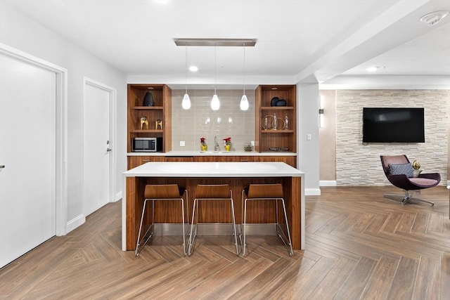 bar with parquet floors, decorative backsplash, sink, and hanging light fixtures