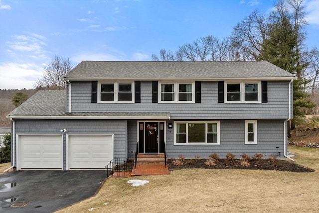 view of front of house with an attached garage, aphalt driveway, and roof with shingles