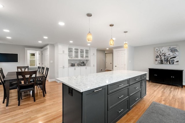 kitchen featuring a center island, decorative light fixtures, recessed lighting, light wood-style flooring, and white cabinetry