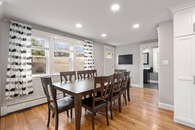 dining space with light wood-type flooring, baseboards, baseboard heating, and recessed lighting