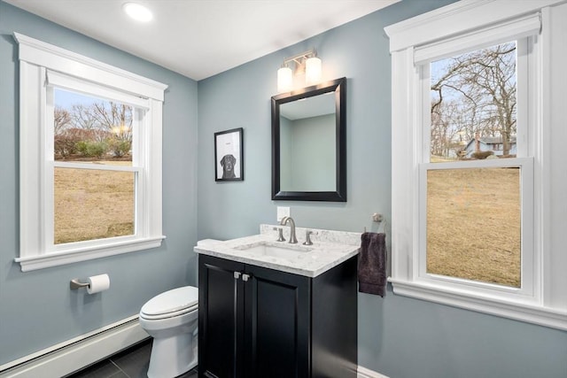 half bathroom with baseboard heating, vanity, and toilet