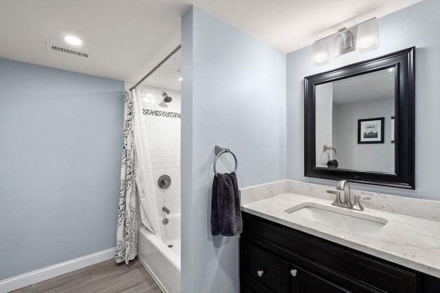 bathroom with baseboards, visible vents, shower / tub combo with curtain, wood finished floors, and vanity