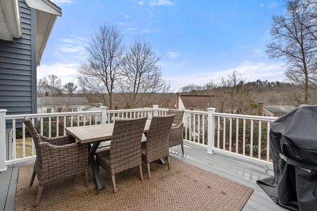 wooden deck with outdoor dining area and grilling area