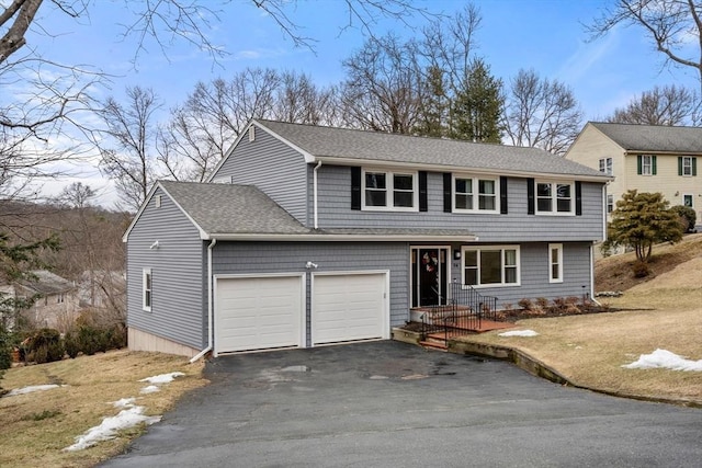 view of front of property featuring aphalt driveway, a shingled roof, and a garage