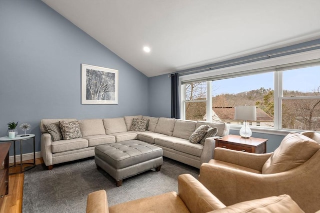 living room with lofted ceiling, baseboards, and wood finished floors