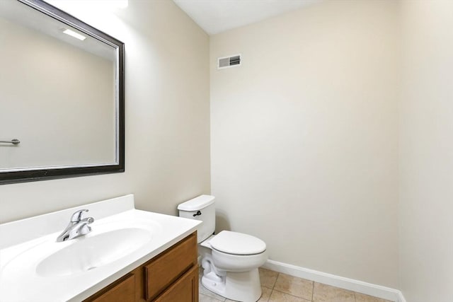 half bathroom featuring visible vents, vanity, tile patterned floors, baseboards, and toilet