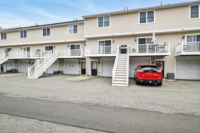 view of front of house featuring stairs, central AC unit, and a garage