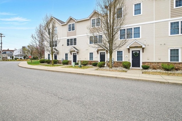 townhome / multi-family property featuring stone siding