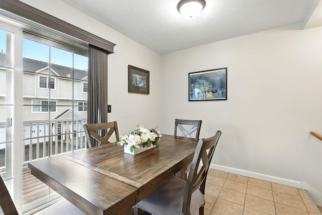 dining space with baseboards and light tile patterned floors