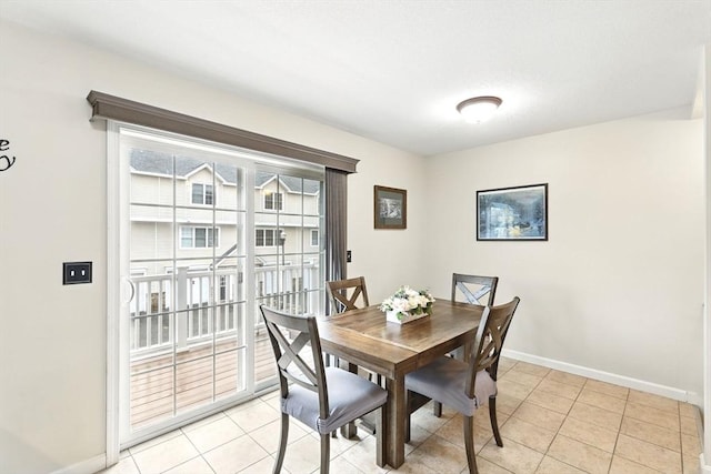 dining area with light tile patterned flooring and baseboards