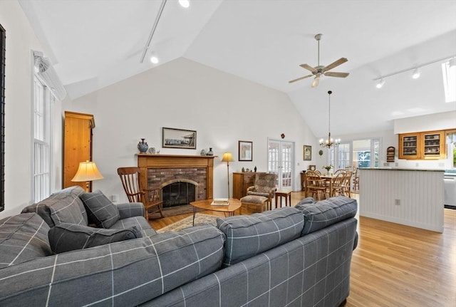 21 Gramps Way, Chatham, MA 02659 - living area with rail lighting, ceiling fan, vaulted ceiling, light wood-style floors, and a brick fireplace