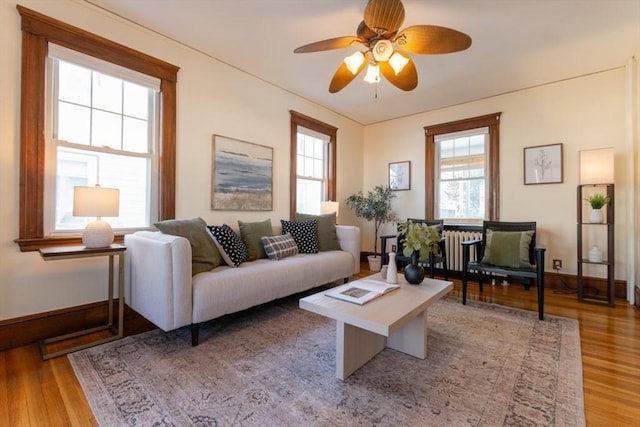 living room with light hardwood / wood-style flooring and ceiling fan