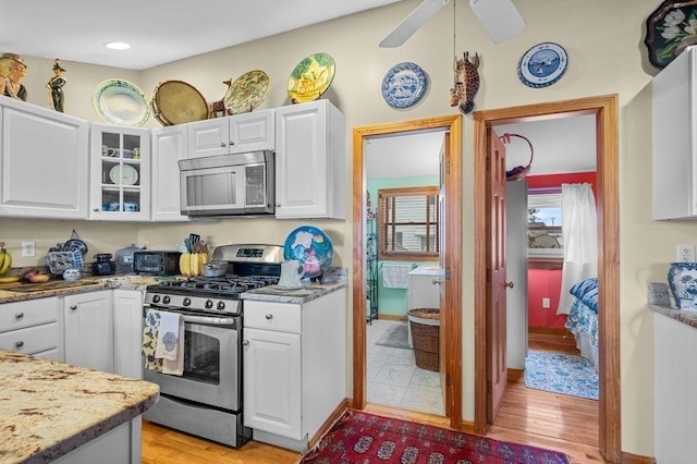 1 Carter Ave, Salisbury, MA 01952 - kitchen featuring appliances with stainless steel finishes, white cabinets, glass insert cabinets, and light wood-style flooring