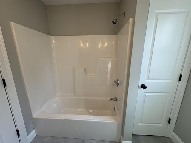 bathroom featuring shower / tub combination and baseboards