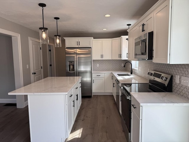 kitchen with a kitchen island, appliances with stainless steel finishes, dark wood-style flooring, a sink, and backsplash