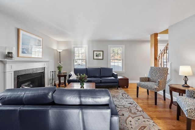 living room featuring a high end fireplace and hardwood / wood-style flooring