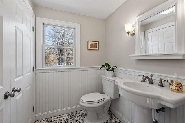 bathroom with toilet, sink, and tile patterned floors