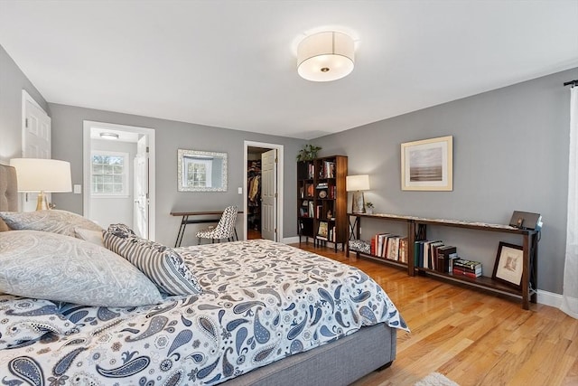 bedroom with wood-type flooring, a closet, and a walk in closet