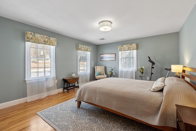 bedroom featuring multiple windows and light hardwood / wood-style floors