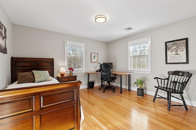 bedroom featuring multiple windows and light hardwood / wood-style flooring