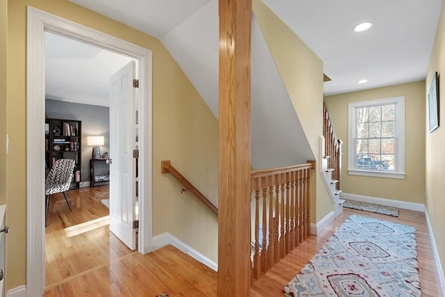 stairway with hardwood / wood-style floors and lofted ceiling