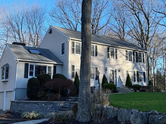 colonial house with a front yard and a garage