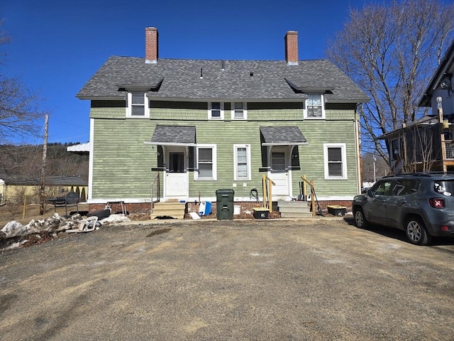 view of front of house featuring a shingled roof and a chimney