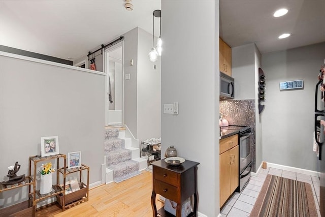 350 W 4th St Unit 103, Boston, MA 02127 - kitchen with black electric range oven, a barn door, decorative backsplash, recessed lighting, and dark countertops