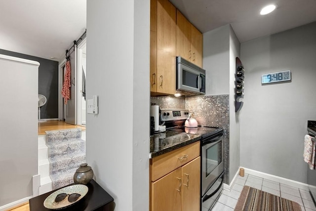 350 W 4th St Unit 103, Boston, MA 02127 - kitchen with stainless steel appliances, a barn door, light tile patterned floors, tasteful backsplash, and baseboards