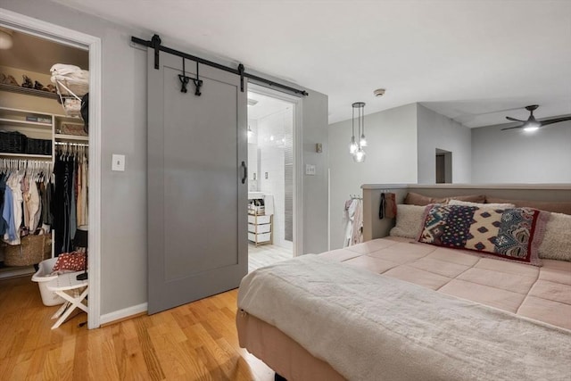 350 W 4th St Unit 103, Boston, MA 02127 - bedroom with a closet, wood finished floors, a barn door, a walk in closet, and baseboards