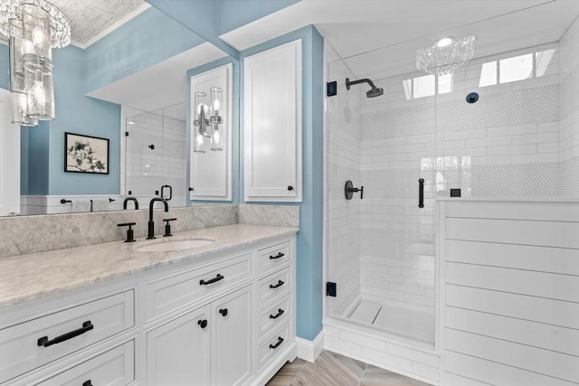 bathroom with vanity, a chandelier, and a shower stall