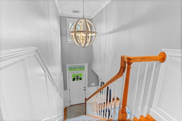 entrance foyer featuring plenty of natural light, ornamental molding, a high ceiling, and a chandelier