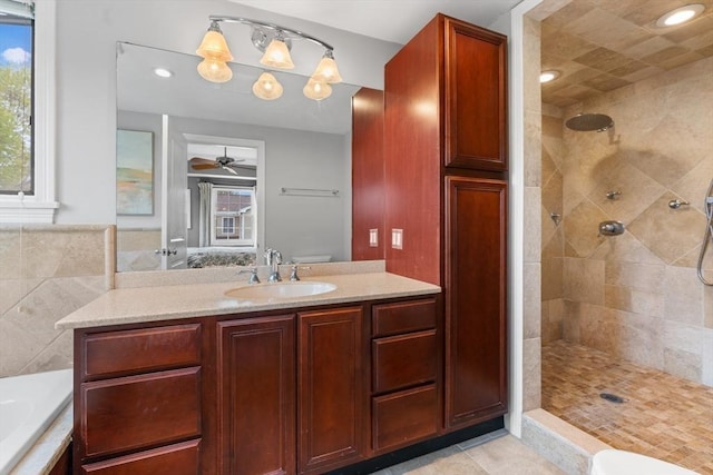 full bathroom with a healthy amount of sunlight, vanity, ceiling fan, and tiled shower